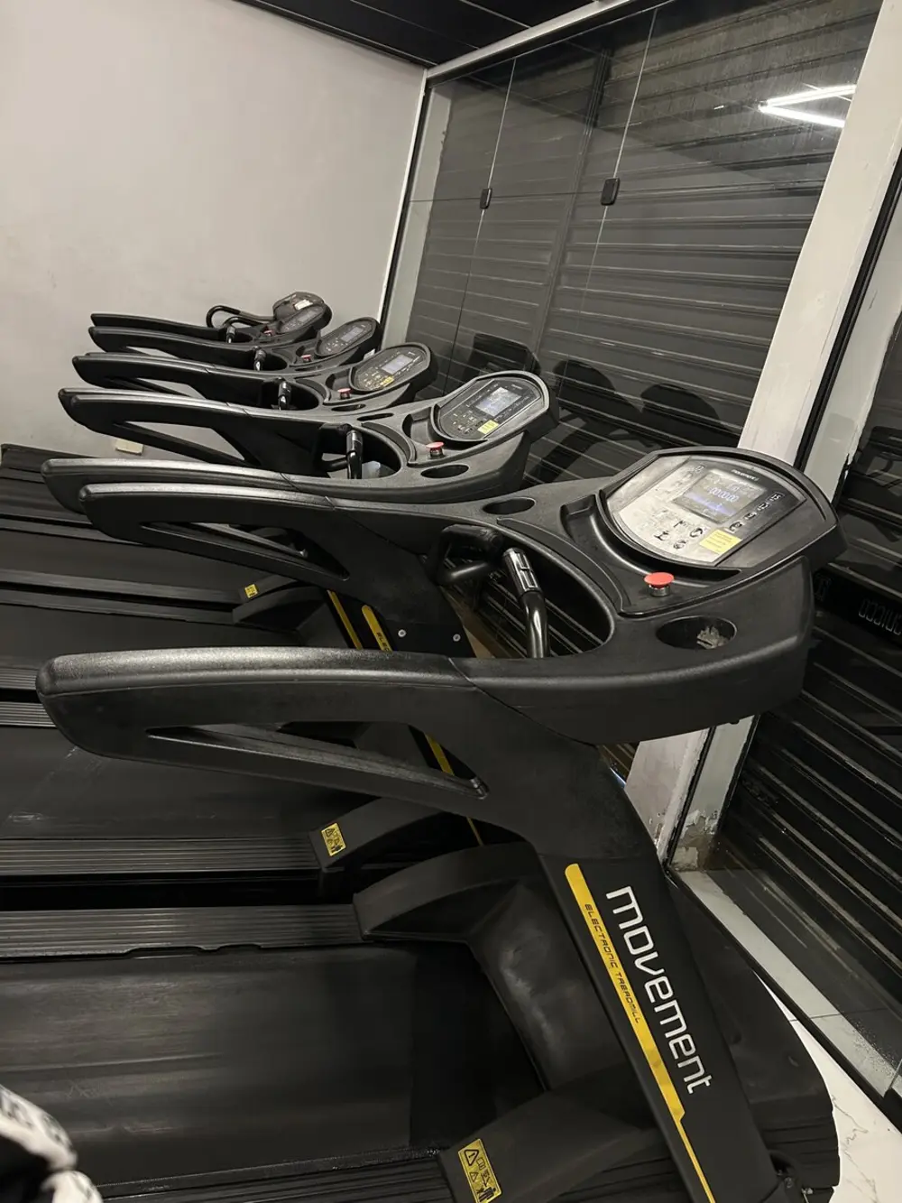 Fileira de esteiras na área de cardio da Guicco